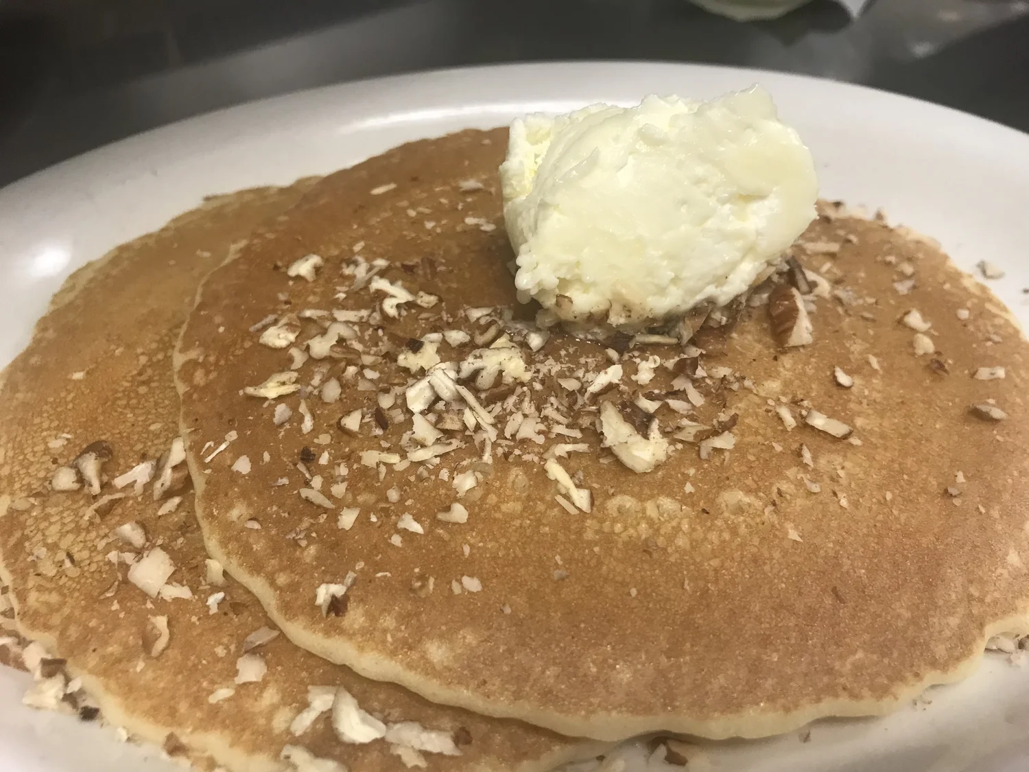 Stack of pecan pancakes with butter